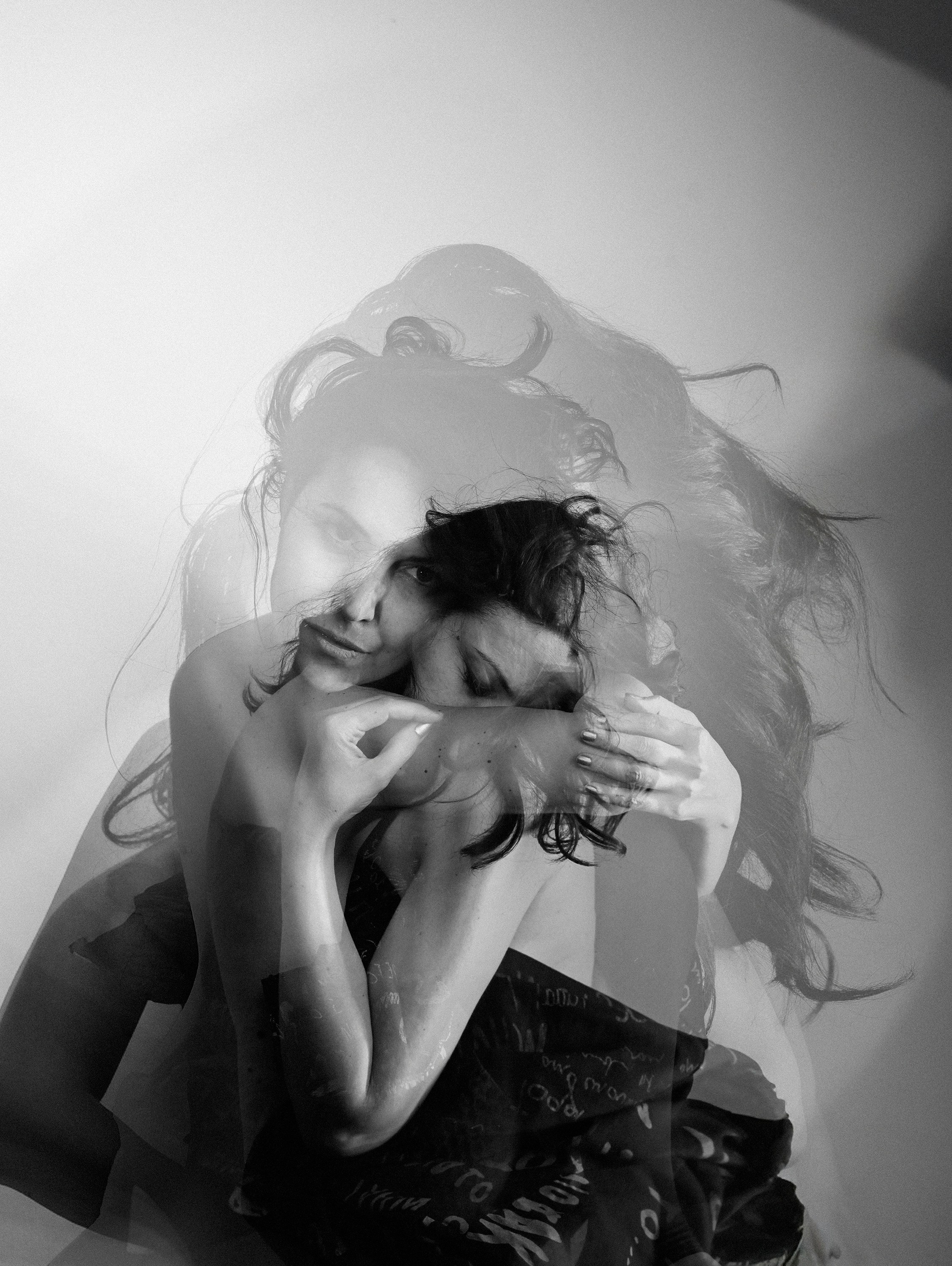 Woman holding herself, double exposure